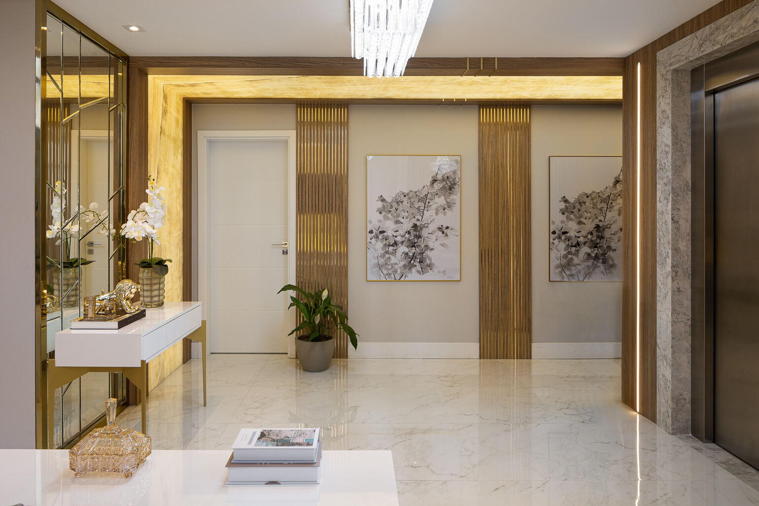 Hall de entrada com marcenaria dourada e piso em mármore