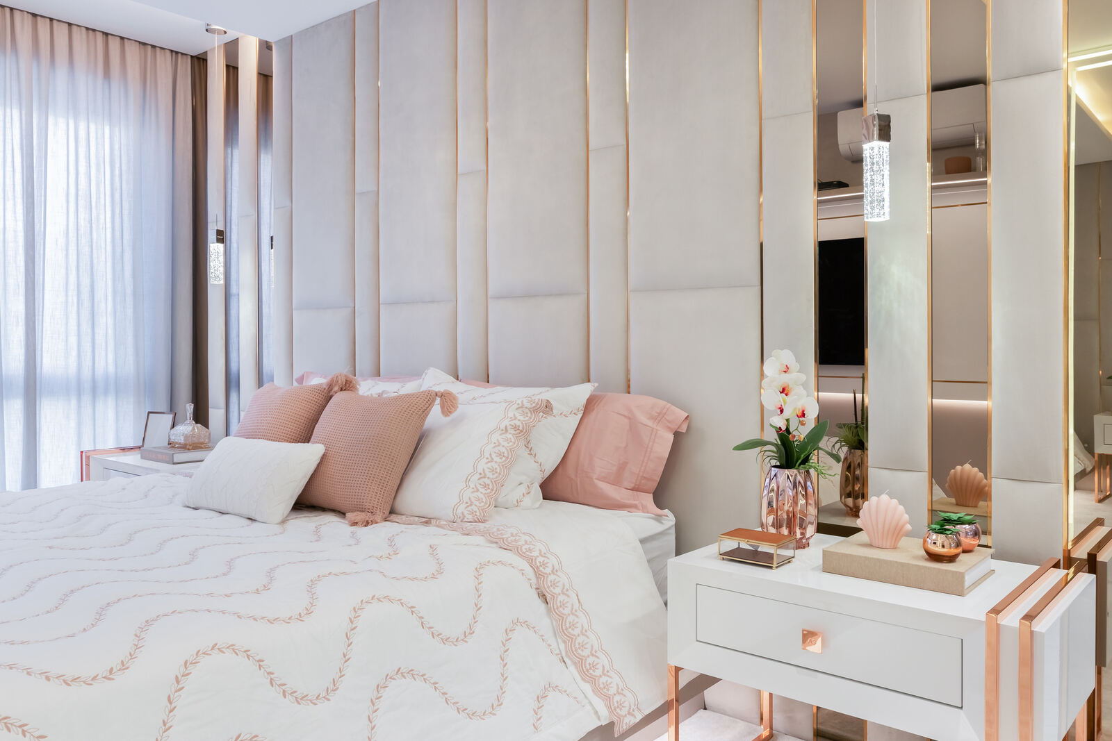 Quarto em tons rosé com cabeceira em painéis espelhados